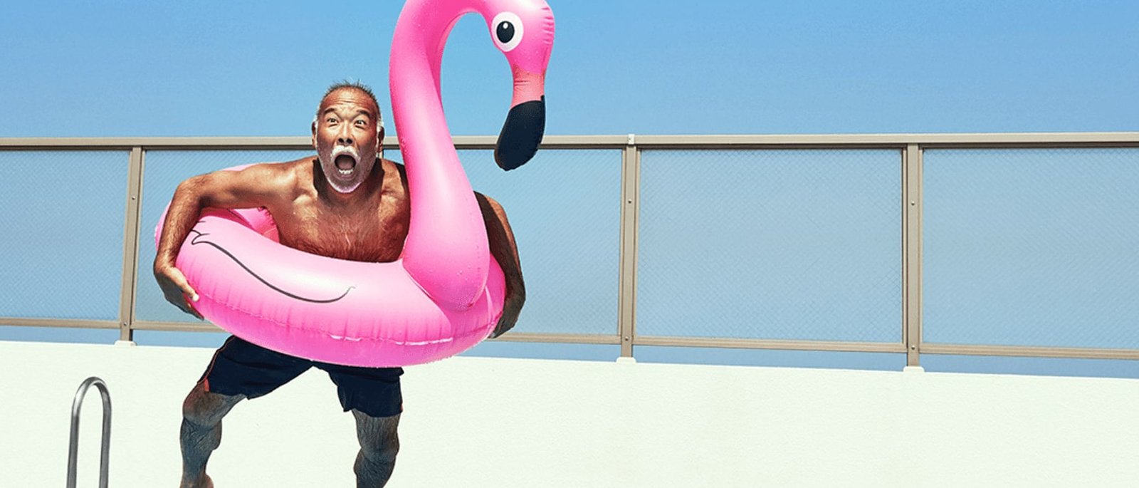 muž skákajúci do bazéna