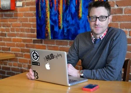 a man sitting at a table with a laptop
